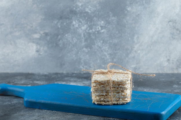 Pan crujiente en cuerda sobre una tabla de cortar de madera.