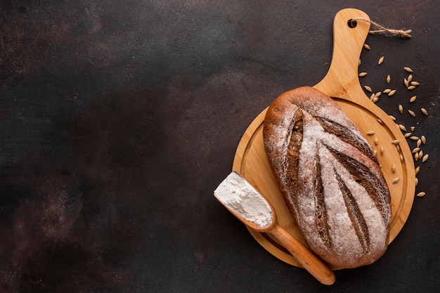 Pan crujiente sobre tabla de madera con semillas de trigo
