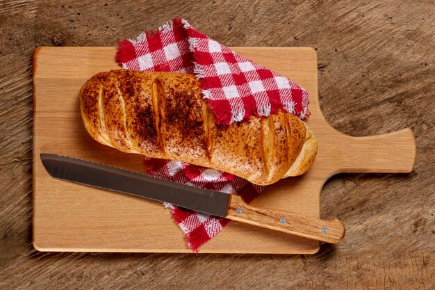 Pan y cuchillo sobre tabla de madera