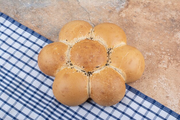 Pan con forma de flor fresca sobre fondo de mármol