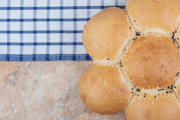 Foto gratuita pan con forma de flor fresca sobre un mantel a rayas