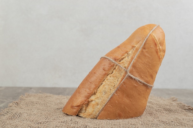 Foto gratuita pan fresco atado con cuerda sobre arpillera. foto de alta calidad