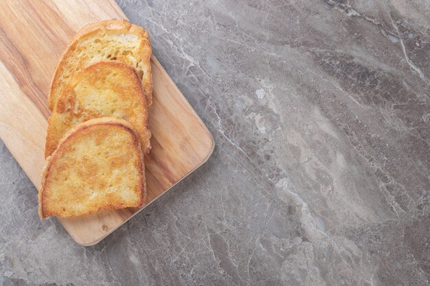 Pan frito con huevo sobre tabla de madera.