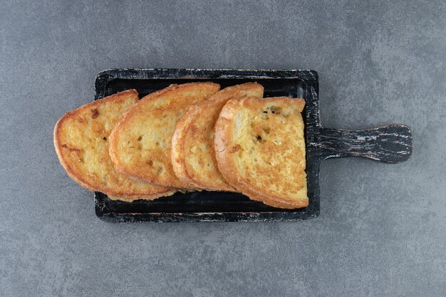 Pan frito con huevo en tablero negro.