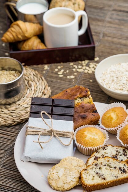 Pan, galletas, magdalenas y chocolate amargo en un plato