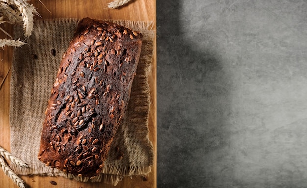 Pan horneado en una servilleta, en una tabla de cortar, vista superior con espacio para publicidad o receta. Pan fermentado naturalmente, comida sana. Diseño en una mesa gris