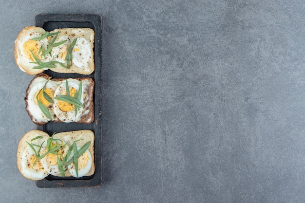 Pan con huevos duros en un plato negro.