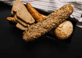 Foto gratuita pan integral con rebanada sobre fondo oscuro