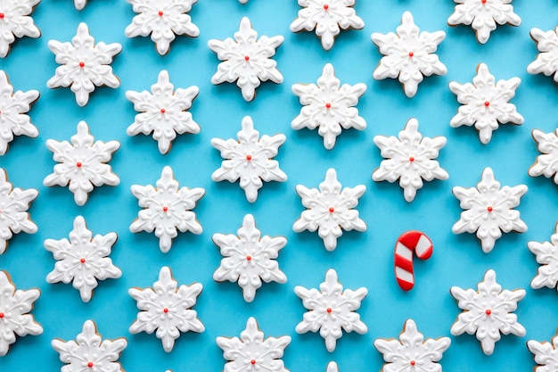 Foto gratuita pan de jengibre en forma de copos de nieve sobre un fondo azul.