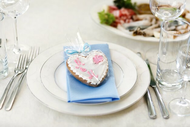 Pan de jengibre en forma de corazón se encuentra en la servilleta azul sobre blanco