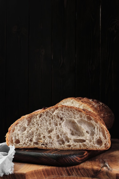 Pan de masa fermentada artesanal fresco en una tabla de cortar Marco vertical de primer plano con espacio de copia