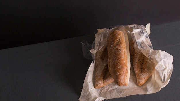 Pan de pan envuelto en papel contra el fondo