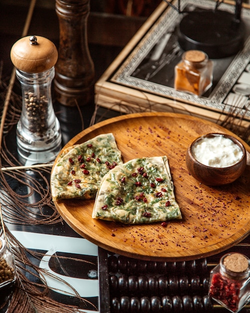 Pan plano relleno de gutab azerbaiyano con hierbas adornadas con semillas de granada y yogurt