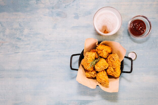 Pan con pollo cerca de ketchup y cerveza