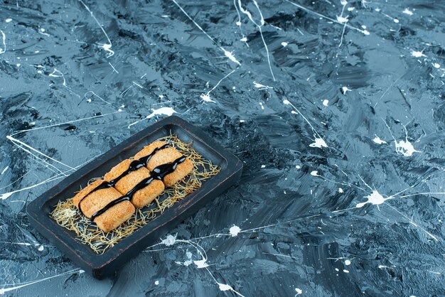 Pan rallado glaseado en una placa de madera, sobre la mesa de mármol.