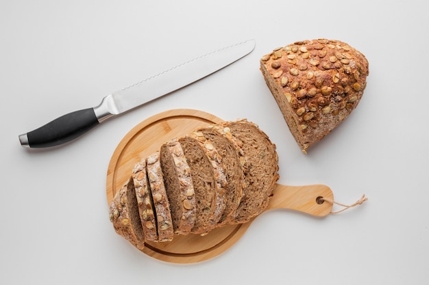 Foto gratuita pan rebanado de tabla de madera con cuchillo