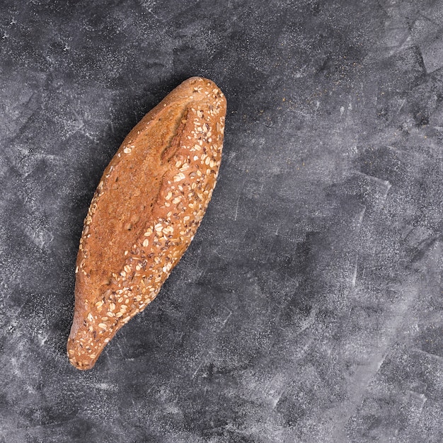 Foto gratuita pan recién horneado de granos múltiples en encimera de cocina negra