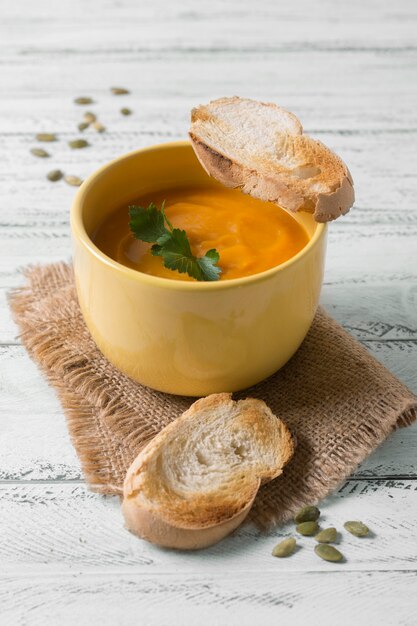 Pan y sopa de crema sabrosa de alto ángulo