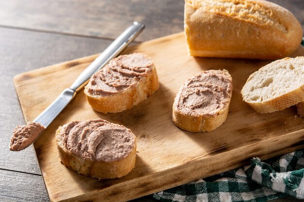 Pan tostado con paté de hígado de cerdo sobre mesa de madera