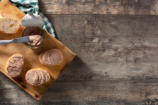 Pan tostado con paté de hígado de cerdo sobre mesa de madera