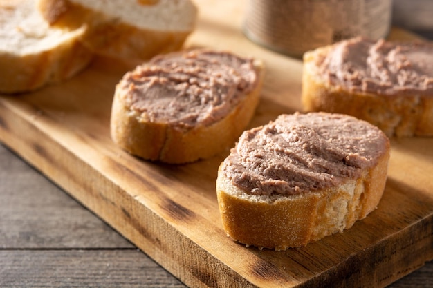 Pan tostado con paté de hígado de cerdo sobre mesa de madera