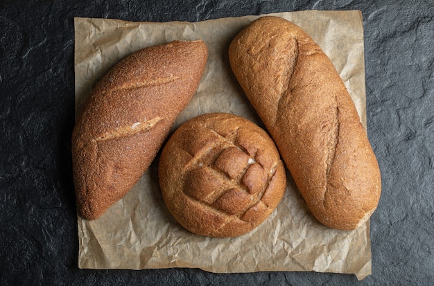 Pan de tres panes diferentes sobre fondo negro.
