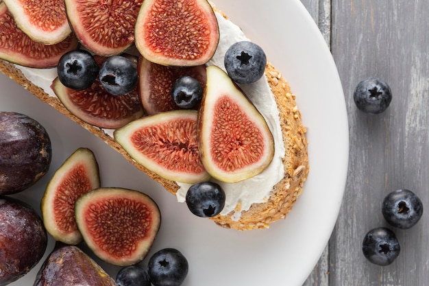 Foto gratuita pan de vista superior con queso crema, higos y arándanos