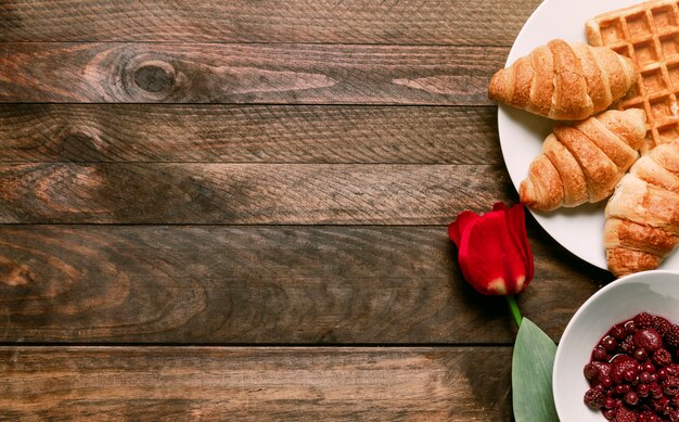 Panadería en plato cerca de mermelada y flor