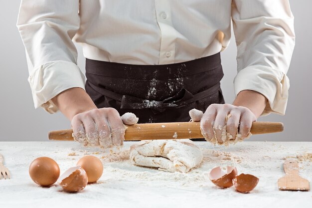 El panadero haciendo pan, amasando una masa