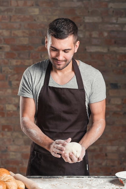 Panadero de sexo masculino que prepara el pan en panadería