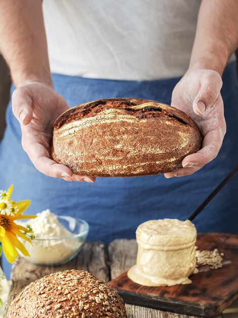 El panadero tiene pan artesanal casero en sus manos