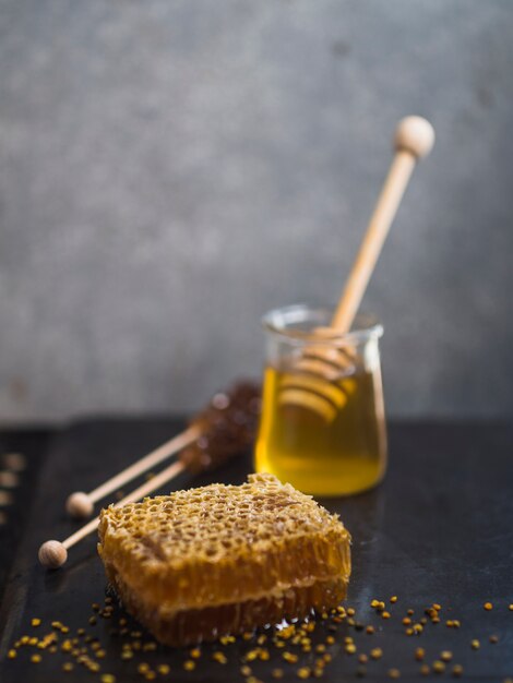 Panal de miel con miel; cucharón de madera y polen de abeja