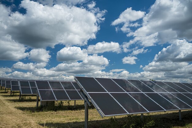 Paneles solares utilizados para energía renovable en el campo bajo el cielo lleno de nubes.