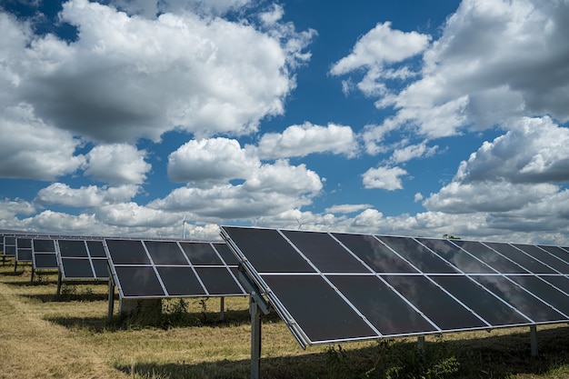 Paneles solares utilizados para energía renovable en el campo bajo el cielo lleno de nubes.