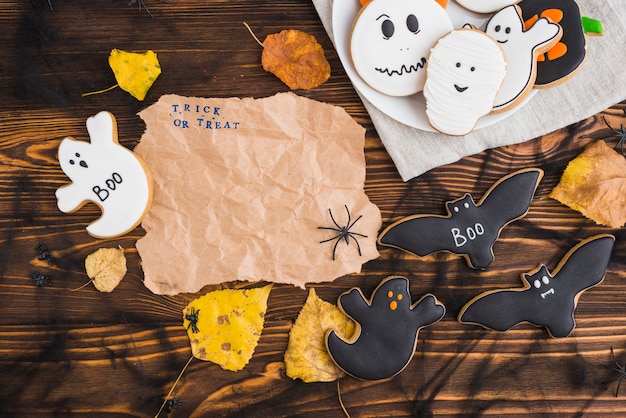 Foto gratuita panes de jengibre de halloween y hojas alrededor de papel artesanal