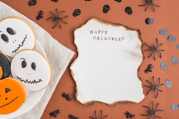 Foto gratuita panes de jengibre de halloween en plato cerca de la hoja ardiente