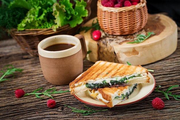 Panini sandwich con queso y hojas de mostaza. Cafe mañanero. Desayuno del pueblo