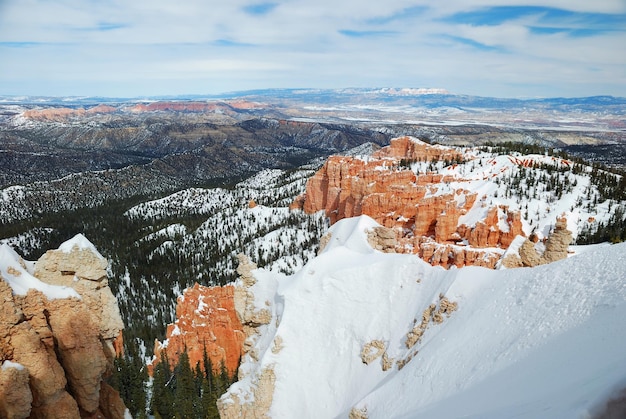 Foto gratuita panorama del cañón bryce con nieve en invierno con rocas rojas y cielo azul.