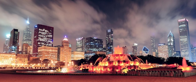 Panorama del horizonte de Chicago con rascacielos y fuente de Buckingham en Grant Park por la noche iluminada por luces de colores.