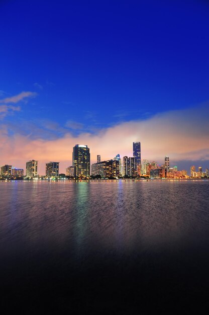 Panorama del horizonte de la ciudad de Miami al atardecer con rascacielos urbanos sobre el mar con reflejo