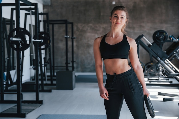 Con panqueque para la caña en mano. Hermosa mujer rubia en el gimnasio en su fin de semana