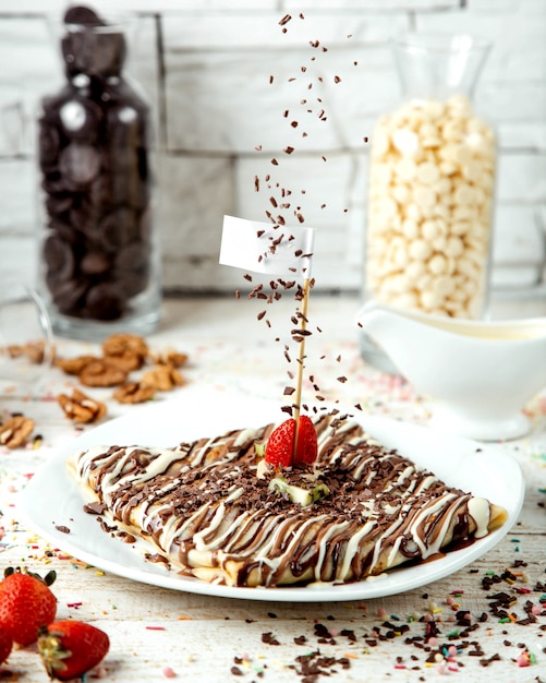 Panqueque cubierto con jarabe de chocolate y espolvorear con pistachos rallados