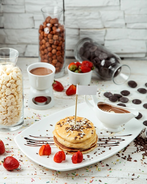 Panqueque con fresas y chocolate sobre la mesa