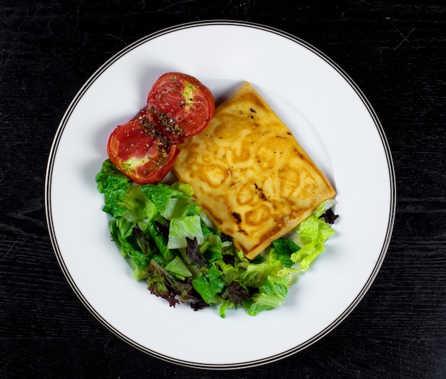 Foto gratuita panqueque frito con tomate y hierbas