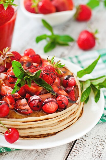 Panqueques con bayas y batido de fresa en un estilo rústico