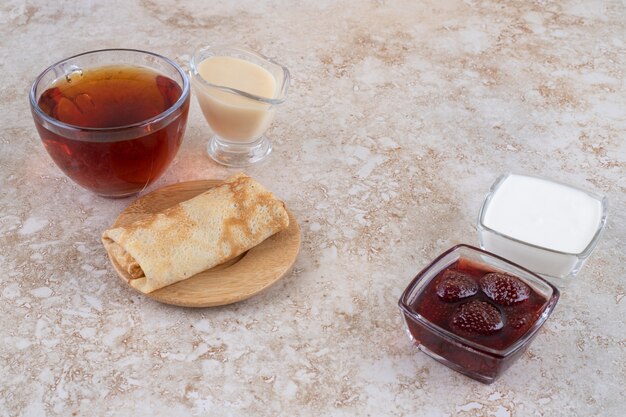 Panqueques con crema agria y una taza de té.