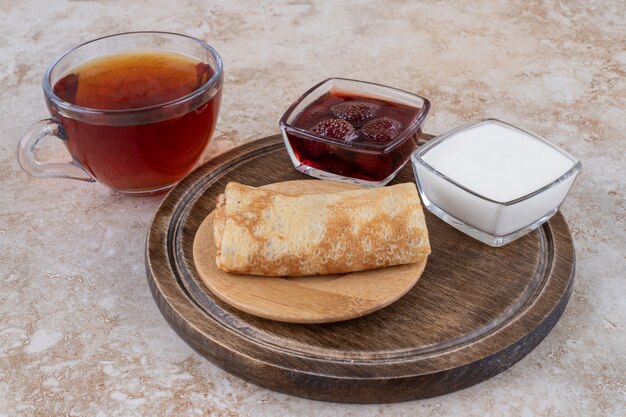 Panqueques con crema agria y una taza de té.