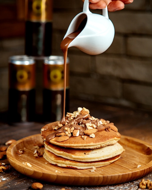 Foto gratuita panqueques cubiertos con nueces y chocolate