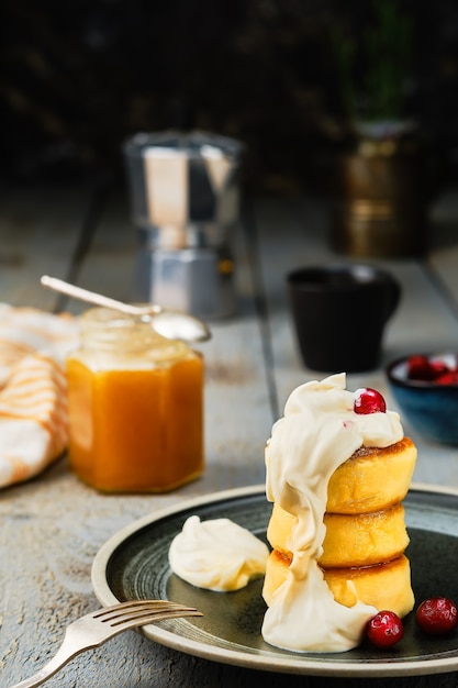 Foto gratuita panqueques de requesón frito o panqueques de queso con crema y miel y una taza de café
