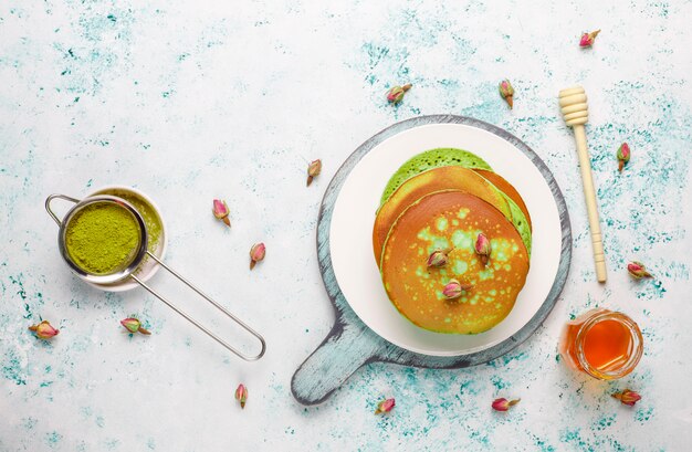 Panqueques verdes con matcha en polvo con mermelada roja en la mesa de luz